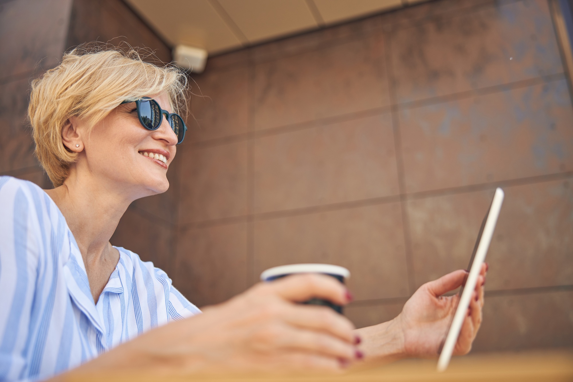 Joyful lady sitting in a street cafe