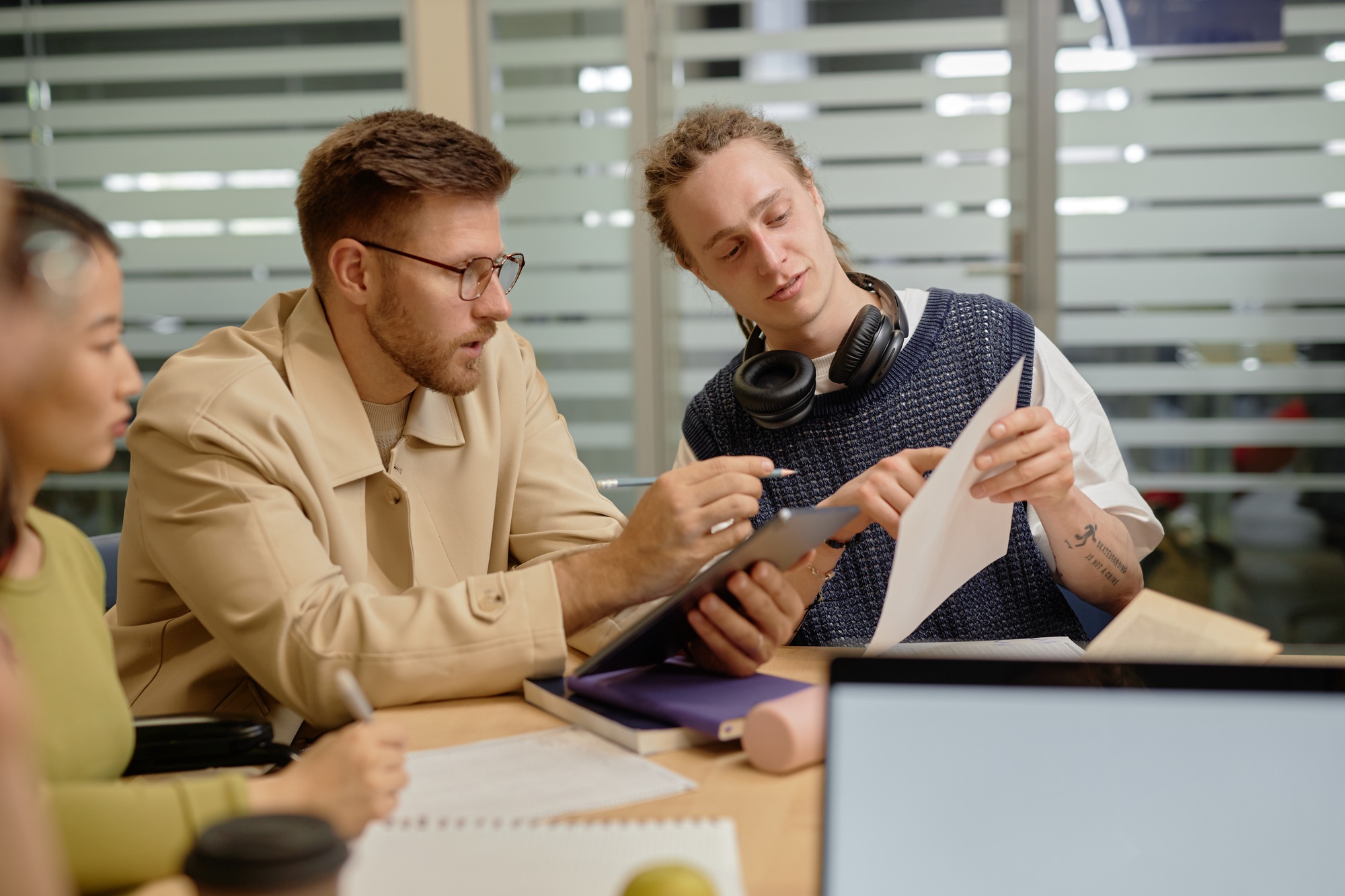 University Student Asking Professor Question Pointing at Paper